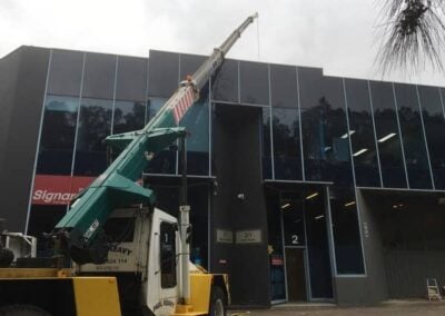 franna crane hire lift airconditioner onto roof of building